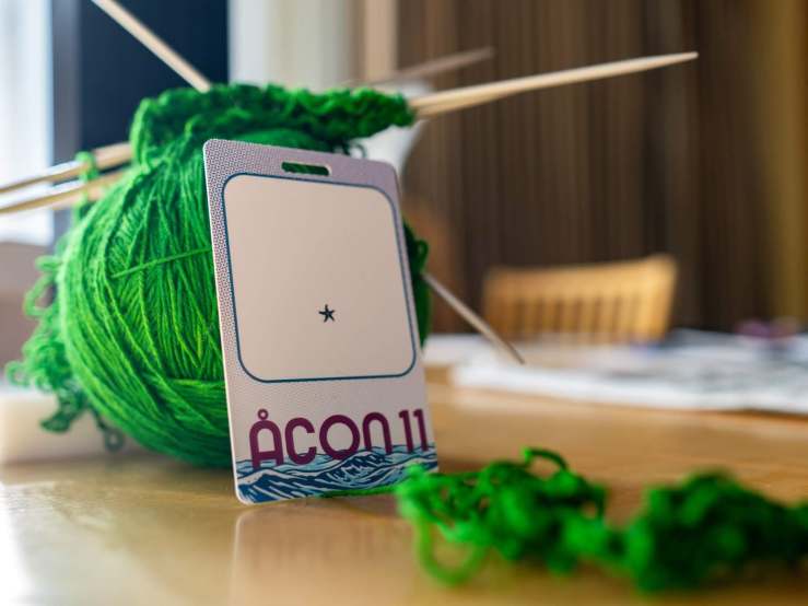 A ball of yarn and an empty Åcon 11 badge.